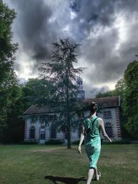 Full length of woman against building and trees against sky