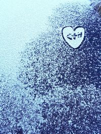 Close-up of heart shape on wet snow