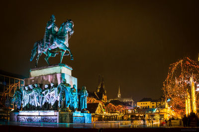 Statue of illuminated building at night - heumarkt köln, weihnachtsmarkt