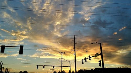 Low angle view of silhouette electricity pylon against sky