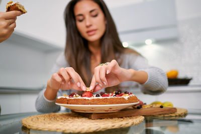 Young woman preparing food on table at home