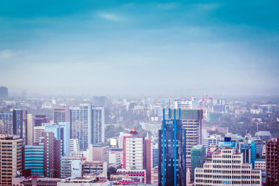 Aerial view of buildings in city against sky