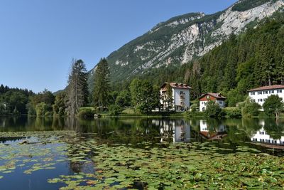 Scenic view of lake by trees and mountains against sky
