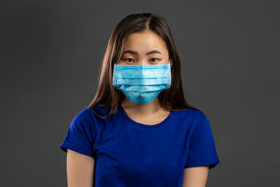 Portrait of beautiful young woman against black background