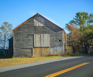 Road by building against clear blue sky