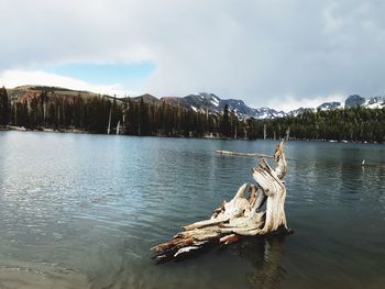 Scenic view of lake by mountain against sky