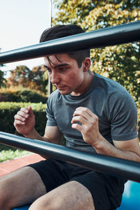 Young man doing sit-ups during his workout in a modern calisthenics street workout park