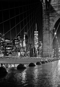 Reflection of illuminated bridge and buildings at night