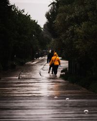 Rear view of man walking on footpath