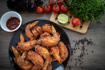 Hot meat dishes - fried chicken wings on plate with salad