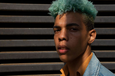 Close-up portrait of young man against wall