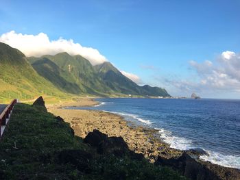 Scenic view of sea and mountains against sky