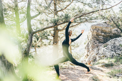 Low angle view of woman standing in forest