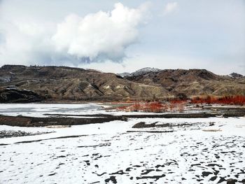 Scenic view of snow covered field against sky