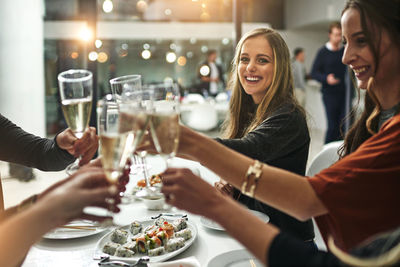 Happy friends toasting wine glasses