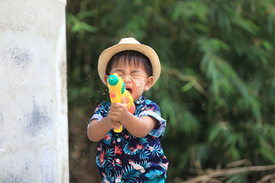 Cue boy playing with water gun outdoors