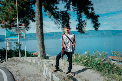 Portrait of young man standing against plants