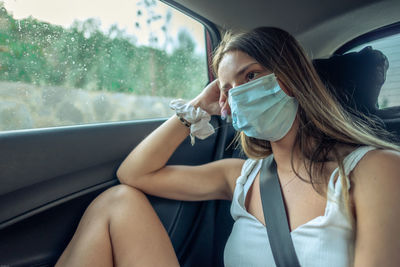 Close-up of girl wearing mask sitting in car