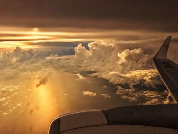 Airplane flying over cloudscape during sunset