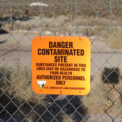 Close-up of warning sign on chainlink fence