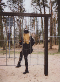 Full length of woman climbing on metallic jungle gym