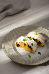 Close up of apple austrian strudel with cinnamon and mint on a plate