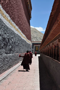 Rear view of woman walking in front of house