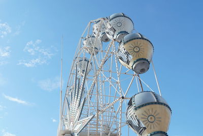 Low angle view of ferris wheel against blue sky