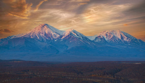 Scenic view of snowcapped mountains against sky during sunset