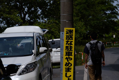 Rear view of man on street against trees