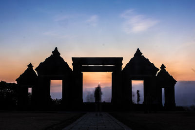 Silhouette historic building against sky during sunset