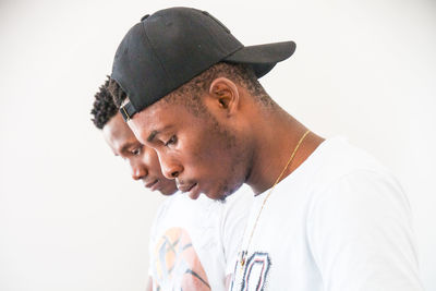 Portrait of young man looking away against white background