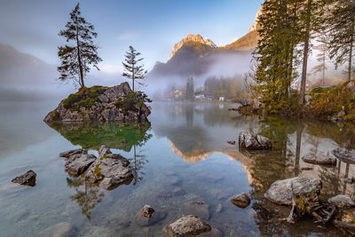 Scenic view of lake by trees against sky