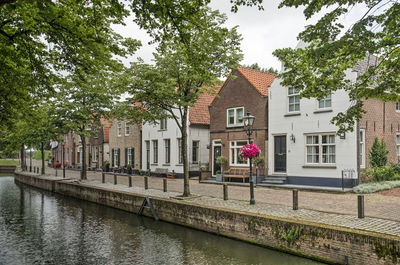 Canal by building against sky