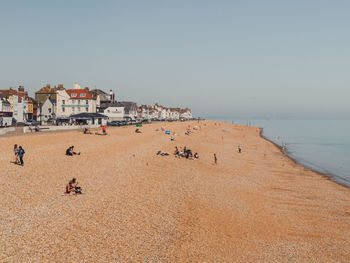 Group of people on beach against clear sky