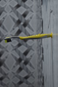 Close-up of yellow wire on fence against blurred background