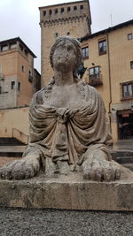Statue against building in city