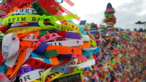 Close-up of multi colored umbrellas hanging against sky