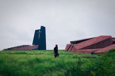 Woman walking on field against sky