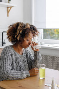 Side view of young woman drinking beer in restaurant