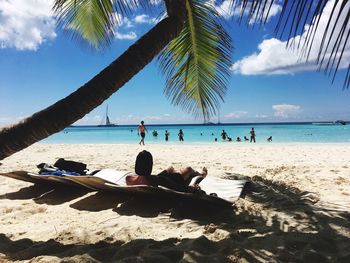Scenic view of people on beach against sky