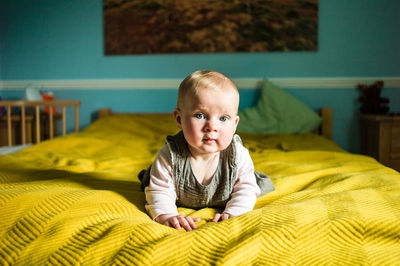 Portrait of cute boy on bed at home