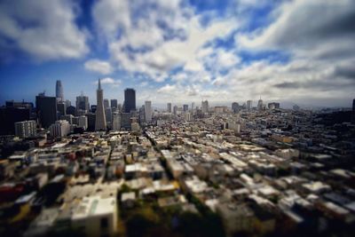 Tilt-shift image of modern buildings in city against sky