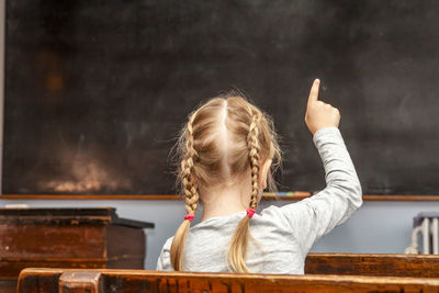 Rear view of girl with arms raised