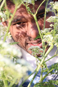 Portrait of man on flowering plant