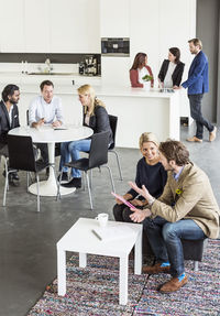 High angle view of business colleague discussing during break in office restaurant