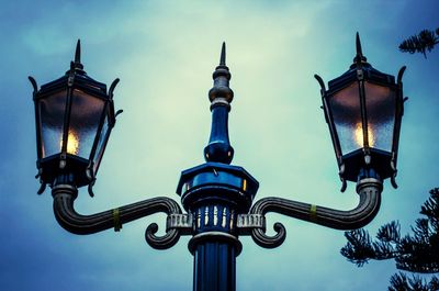 Low angle view of illuminated street light against blue sky