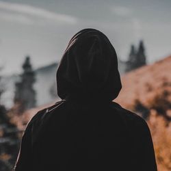 Rear view of silhouette man standing against sky