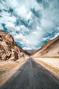 Road amidst land against sky