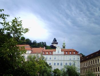 Low angle view of trees and buildings against sky